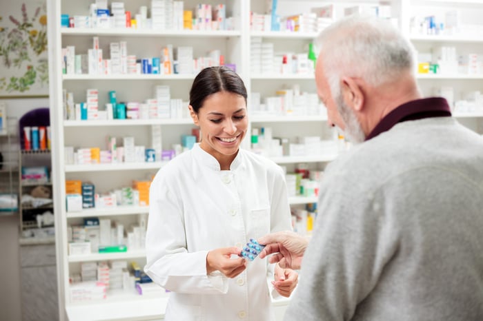 Pharmacist dispensing medicine at a pharmacy counter